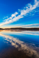 Still lake at sunrise captures the tranquil beauty of Sweden reflected in calm waters