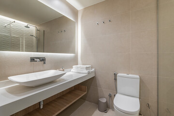 Elegant bathroom with warm beige tiles, modern fixtures, and a stylish minimalist design