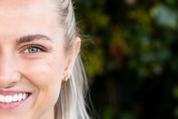 Smiling woman with blonde hair enjoying nature, showing happiness and positivity, copy space