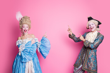 A joyous couple dressed in elegant historical costumes, posing enthusiastically against a vibrant...