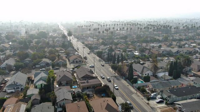 Panorama by aerial view of the South Los Angeles. Houses, buildings, cars, trees along the streets. Typical urban residential area of Los Angeles. Drone shot. Real estate concept