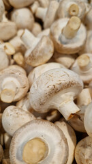 Sale of champignons in a supermarket. Champignons, close-up. Mushrooms in a store. A pile of champignons for sale at the market with selective focus