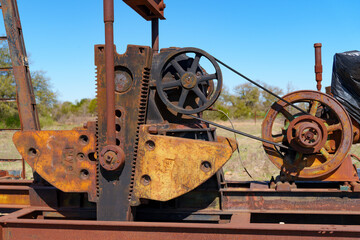 Idle, rusty oil well pumping equipment abandoned in field in West Texas.