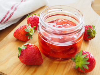 ガラスの器に入れた甘い苺ジャムと新鮮な苺