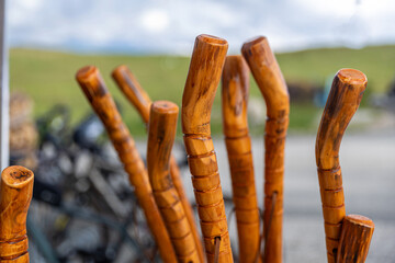 Traditional Austrian hiking poles in large quantities against the background of the green Alps
