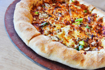 Delicious pizza with meat, onions, mushrooms and cheese