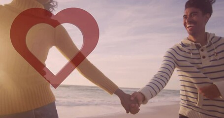 Holding hands on beach, couple enjoying sunset with heart animation overlay - Powered by Adobe