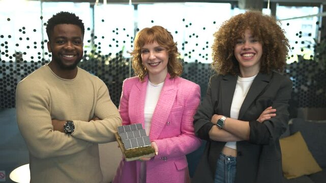Engineers smiling and holding small solar panel
