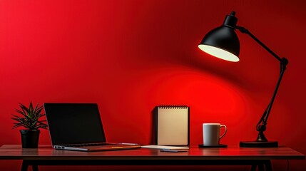 Desk workspace laptop notepad coffee mug lamp and plant against a vibrant red color backdrop