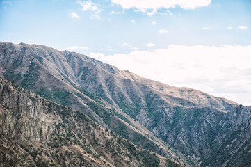 Majestic mountains of Armenia under a sky filled with clouds, showcasing natural beauty and rugged terrain