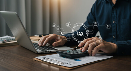 A focused professional meticulously calculates taxes using modern technology, illuminated by soft office lighting on a sleek wooden desk.