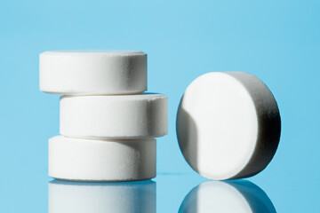  White pills on blue background. Selective focus