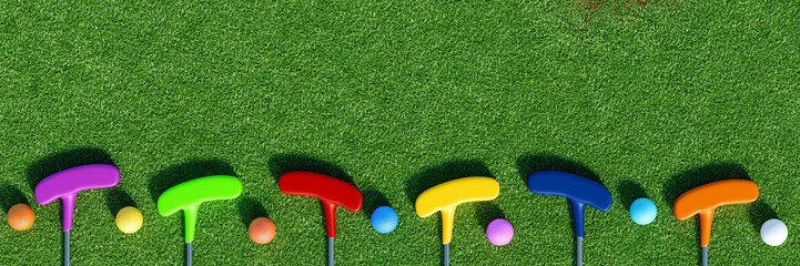 Colorful mini golf balls and clubs on green grass