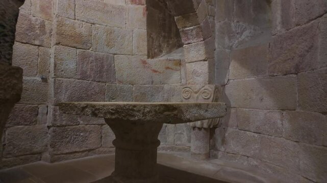 Horizontal footage capturing a vertical ascent from the stone floor to the vaulted ceiling of the central apse in the crypt of Leyre Monastery, Spain. The video showcases Romanesque architecture
