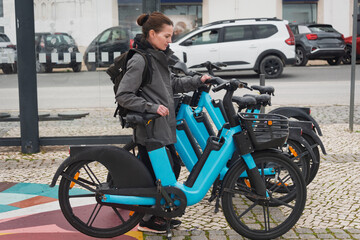 Woman holding a rental bicycle in a city street