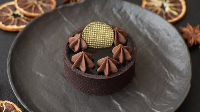 Chocolate tart or dessert with fruit and nuts. Sweet pastries on a dark concrete background