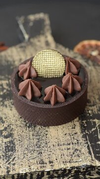 Chocolate tart or dessert with fruit and nuts. Sweet pastries on a dark concrete background