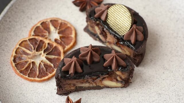 Chocolate tart or dessert with fruit and nuts. Sweet pastries on a dark concrete background