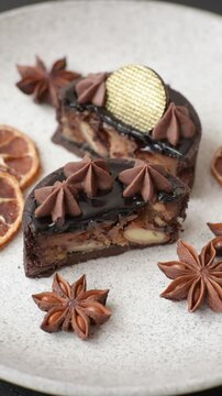 Chocolate tart or dessert with fruit and nuts. Sweet pastries on a dark concrete background