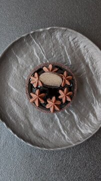Chocolate tart or dessert with fruit and nuts. Sweet pastries on a dark concrete background