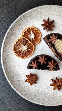 Chocolate tart or dessert with fruit and nuts. Sweet pastries on a dark concrete background