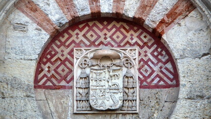 Bas relief coat of arms above a door in the outer wall of the Mosque-Cathedral of Cordoba, in the historic center of Cordoba, Spain