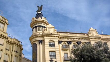 Obraz premium Statue on the roof of a turn of the century insurance building at the edge of the historic center of Cordoba, Spain