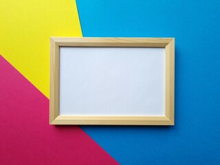 Empty rectangular wooden photo frame on color background