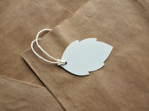 Blank tag with string on craft paper bags close up