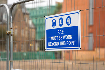 Blue and White PPE Must Be Worn Construction Site Warning Sign on Temporary Heras Fence Panel with...