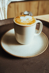 close-up photo of cappuccino with late art (artistic drawing), preparation made with espresso coffee and texturized milk in Colombian coffee shop