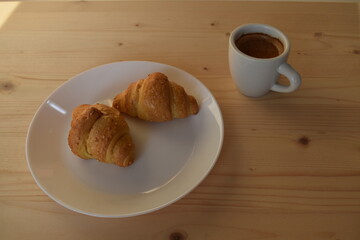Two fresh croissants with coffee