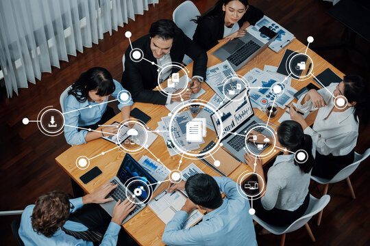 A diverse team engaged in a collaborative meeting in a modern office setting, utilizing technology and data analysis to drive effective management and decision-making processes. Amity