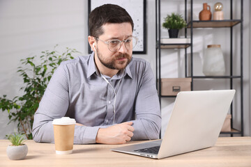 Online speaker streaming webinar with laptop at table indoors