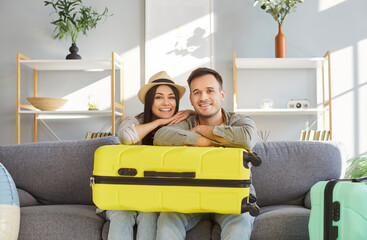 Happy newlywed couple, young family of tourists with suitcases packed, wheel luggage for summer...