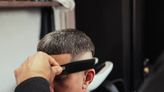 Talented hairdresser skillfully cuts hair in a lively barbershop. Clients enjoy a vibrant atmosphere while getting modern styles and personalized service