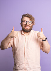 Naklejka premium Crazy funny man showing double thumbs up on purple background. Positivity, humor and enthusiastic support through expressive body language.