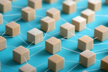 A collection of small wooden blocks arranged in a pattern on a blue surface, with some blocks connected by thin, visible threads to illustrate collaboration and teamwork.