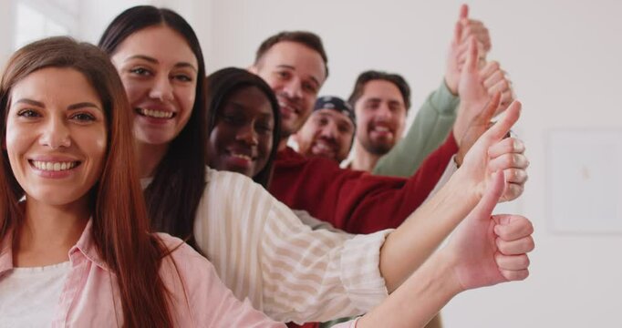 Multinational group of business people posing together and showing thumbs up or like gestures. Team represents teamwork, collaboration, and approval in a professional and diverse setting.