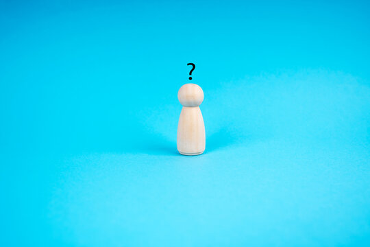 Human wood figurine with Question Mark on blue background. Curiosity, the desire to learn concept
