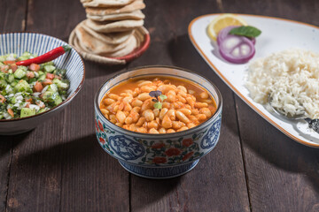 Stew Beans With Rice, pita Bread and Salad served in bowl isolated wooden table side view of savory Turkish dish