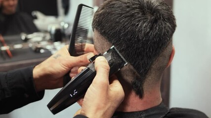 A skilled hairdresser performs a precise haircut in a lively barbershop setting. The client receives a fresh style, demonstrating attention to detail and professionalism in the craft