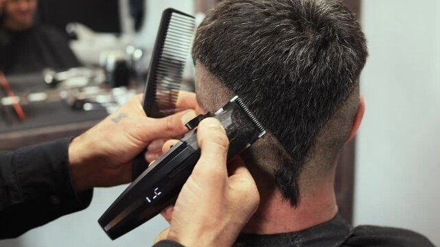 A skilled hairdresser performs a precise haircut in a lively barbershop setting. The client receives a fresh style, demonstrating attention to detail and professionalism in the craft