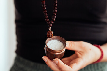 Vibhuti sacred ash in a copper container with Rudraksha mala. Spiritual Hindu ritual...
