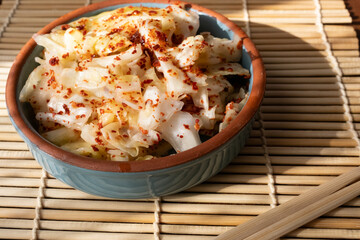 kimchi in fresh white bowl close-up on gray background	
