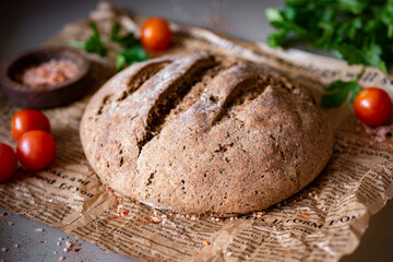 Homemade rye bread. A loaf of homemade bread on a newspaper. Close-up