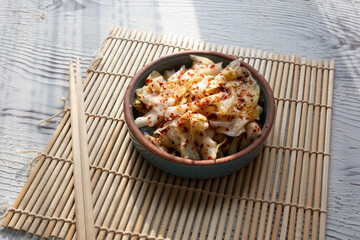 kimchi in fresh white bowl close-up on gray background	