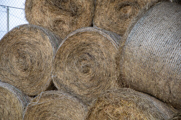 Hay and animal feed in bales in an open warehouse.