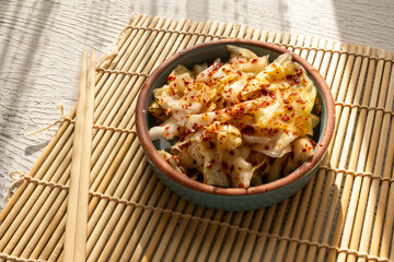 kimchi in fresh white bowl close-up on gray background	