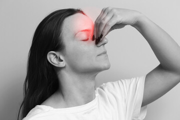 Woman holding her nose. Painful facial expression. Sinus pressure and discomfort. Chronic sinus...